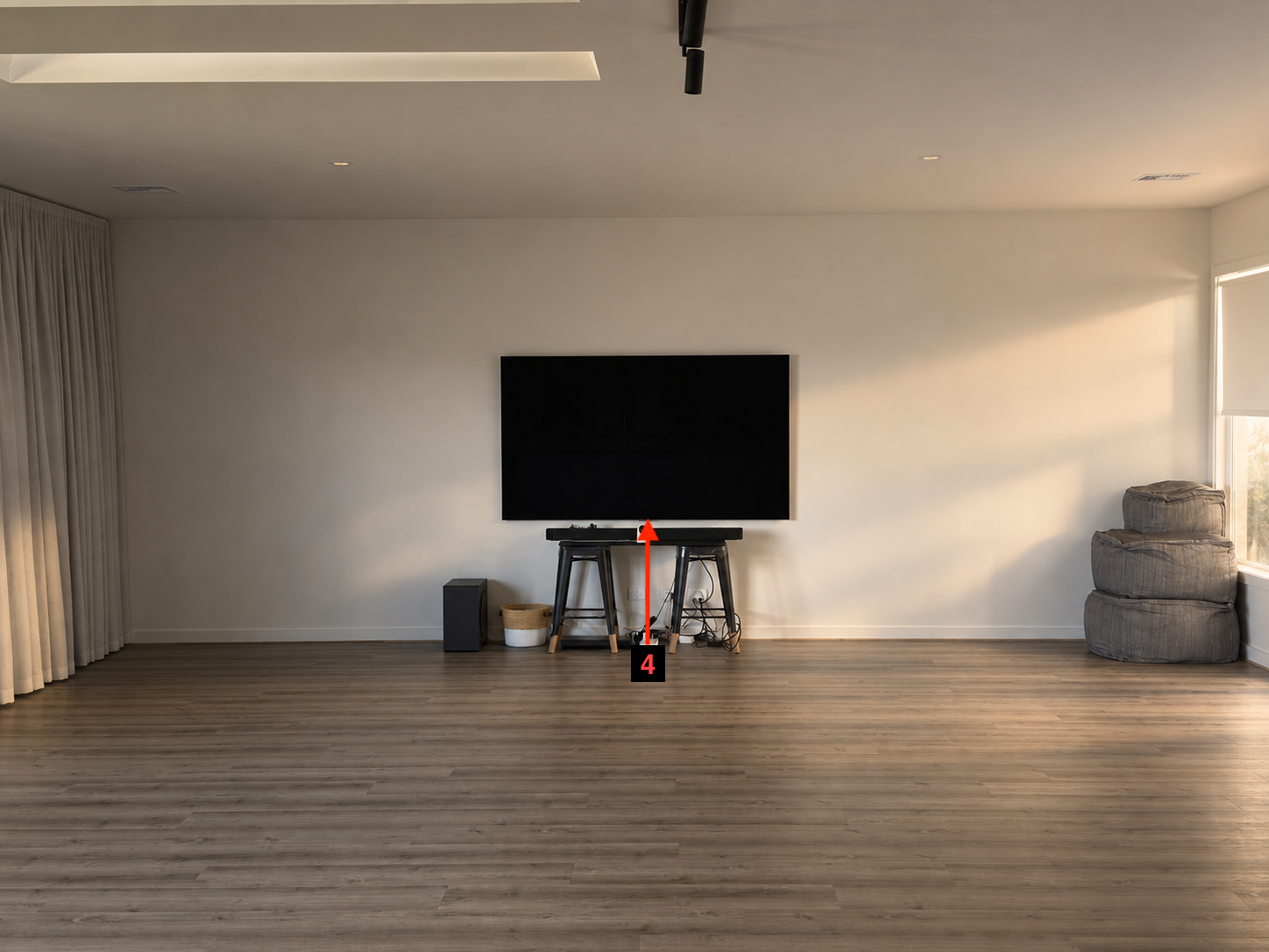 Photo of the TV wall with a red arrow marking the centre of the TV, where the pull-down panel should align.
